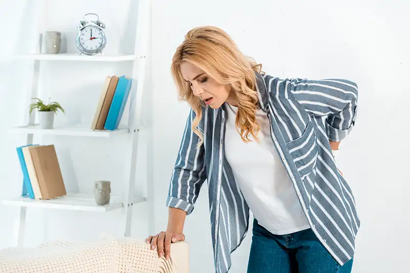 attractive-woman-touching-back-while-suffering