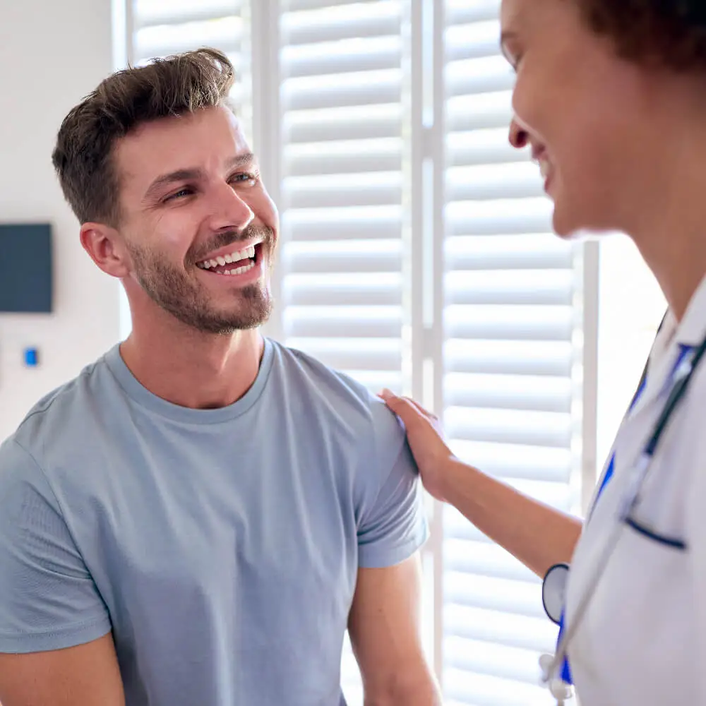 A patient smiles as he receives pain management treatment in North Dallas
