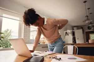 A woman with back pain in need of pain management in North Dallas, Frisco, Plano & beyond