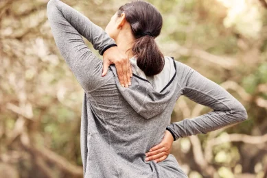 A woman struggles with back pain in North Dallas